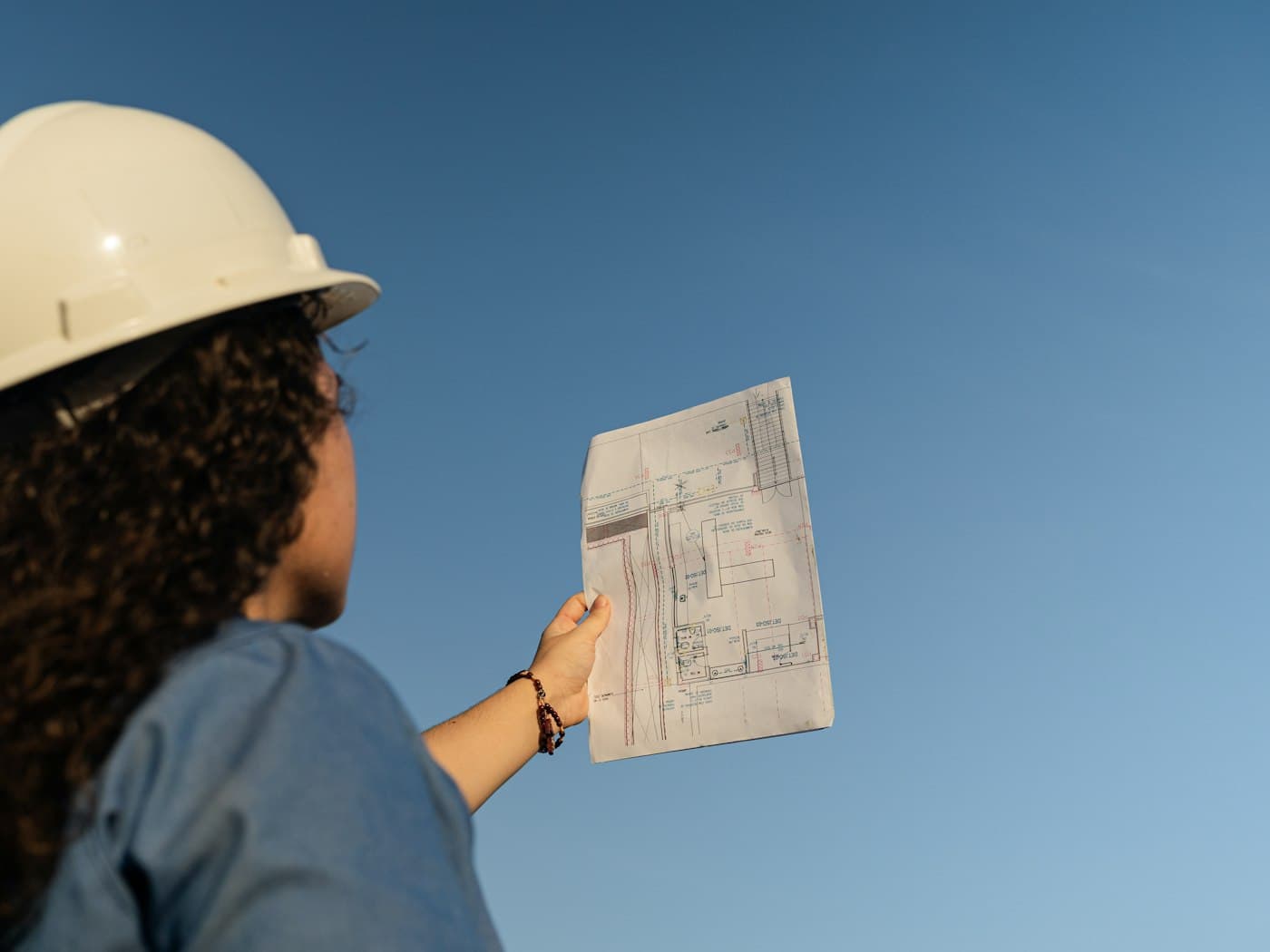 A site supervisor checking a drawing against the building