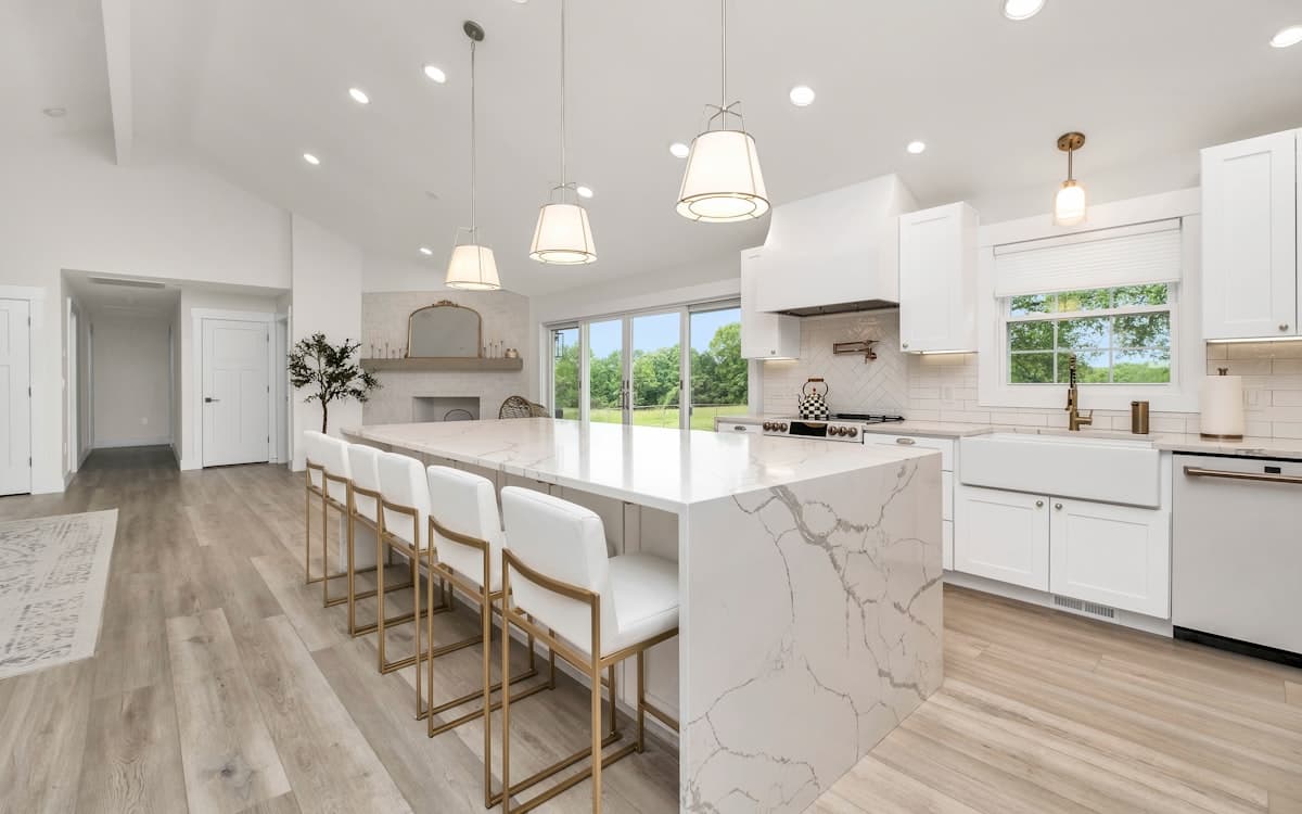 A renovated kitchen with an island and pale cabinetry